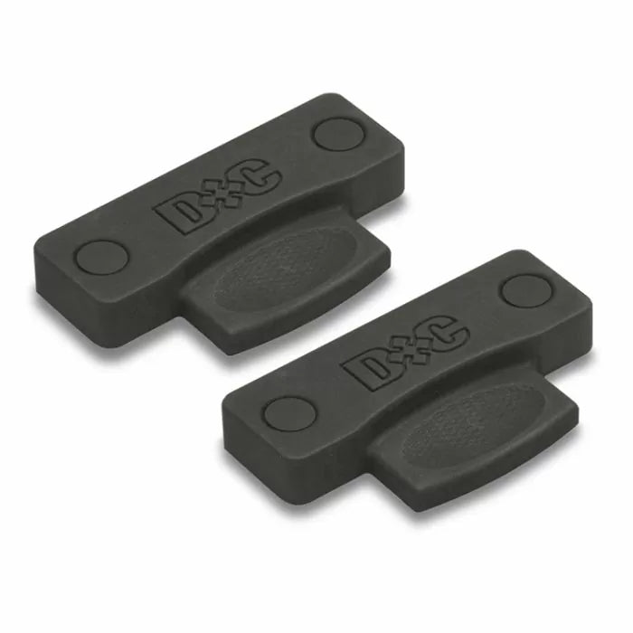 Two black plastic woodworking joiner biscuits with D&C marking for panel alignment