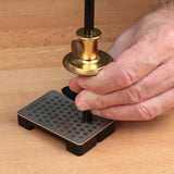 Hand using a brass marking gauge on a dovetail alignment board for precise woodworking