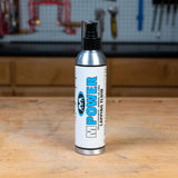 MPOWER lapping fluid bottle on a woodworking bench in a workshop setting