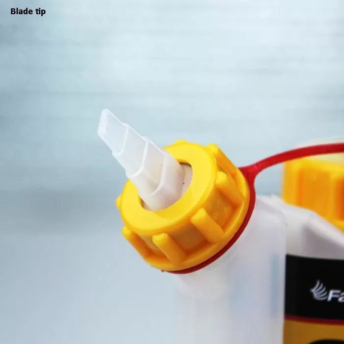 Close-up of woodworking glue bottle with yellow cap and blade tip nozzle