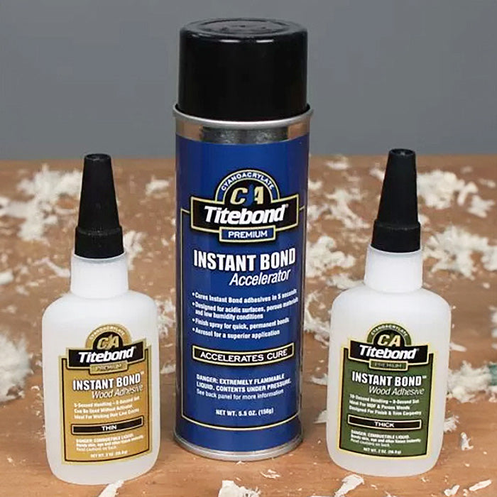Titebond Instant Bond wood adhesive bottles and accelerator can on a woodworking table with shavings