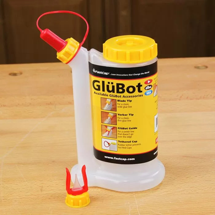GlüBot glue bottle with yellow cap and red nozzle on a woodworking bench