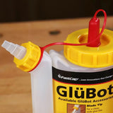 GlüBot glue bottle with yellow cap and blade tip for woodworking projects on a workbench