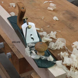 Woodworking hand plane on workbench with wood shavings and labeled 101-572