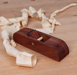 Wooden hand plane for woodworking on a workbench with wood shavings