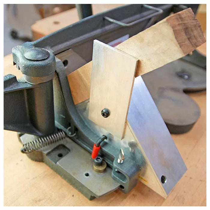 Woodworking miter saw jig holding a wood piece at an angle on a workbench