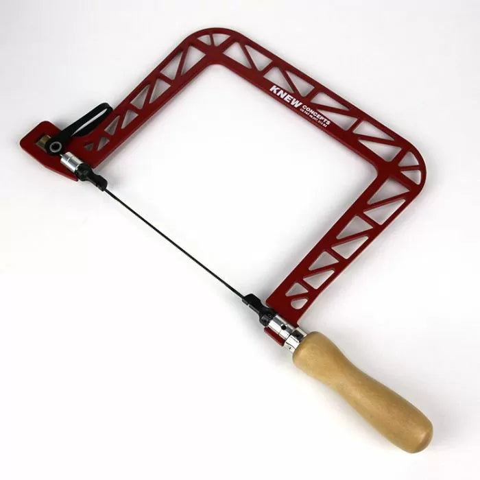 Red metal coping saw with wooden handle on a white background, woodworking hand tool.