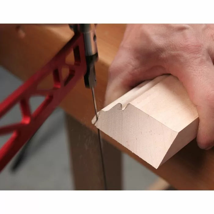 Cutting a decorative wood molding with a bandsaw on a workbench, woodworking tools