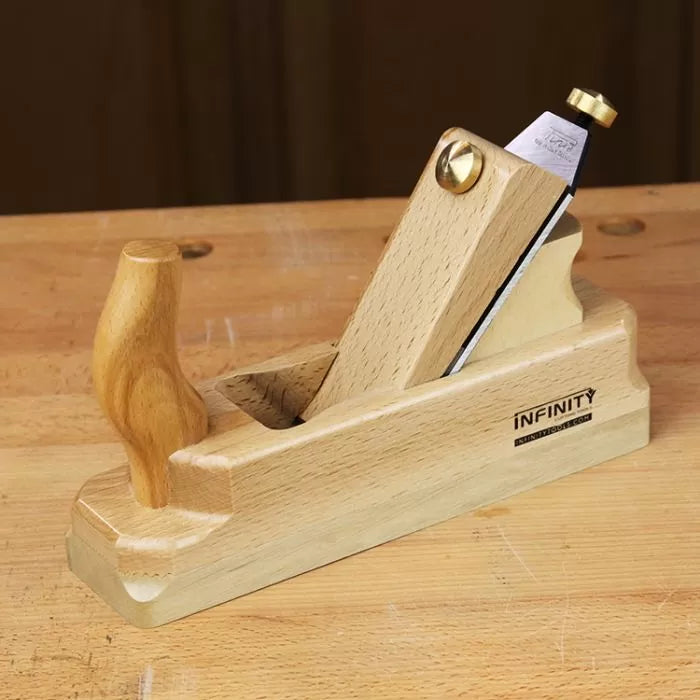 Wooden hand plane for woodworking on a workbench, featuring ergonomic handle and sharp blade.