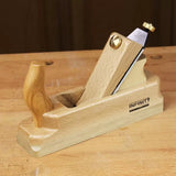 Wooden hand plane for woodworking on a workbench, featuring ergonomic handle and sharp blade.