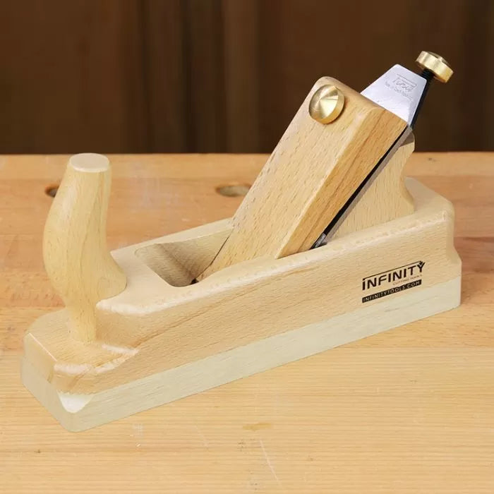Wooden hand plane tool with beech handle on a workbench, ideal for woodworking projects.