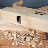 Wooden hand plane for woodworking on table with wood shavings and smooth planed surface