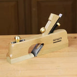 Wooden hand plane with brass knobs on a workbench for woodworking joinery