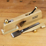 Wooden shoulder plane hand tool with brass fittings on a workbench, ideal for woodworking