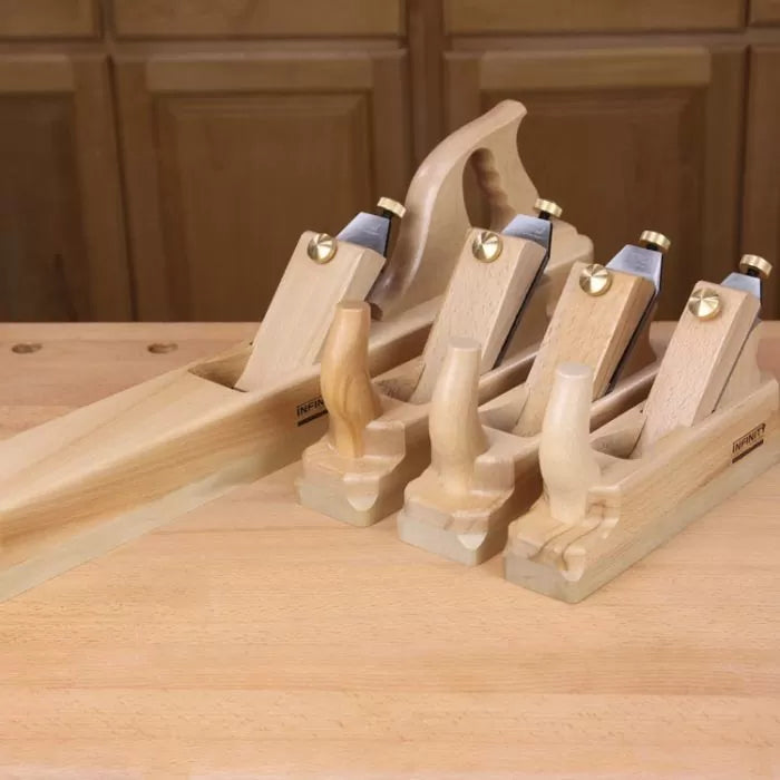 Set of four wooden hand planes on a workbench for woodworking and carpentry tasks