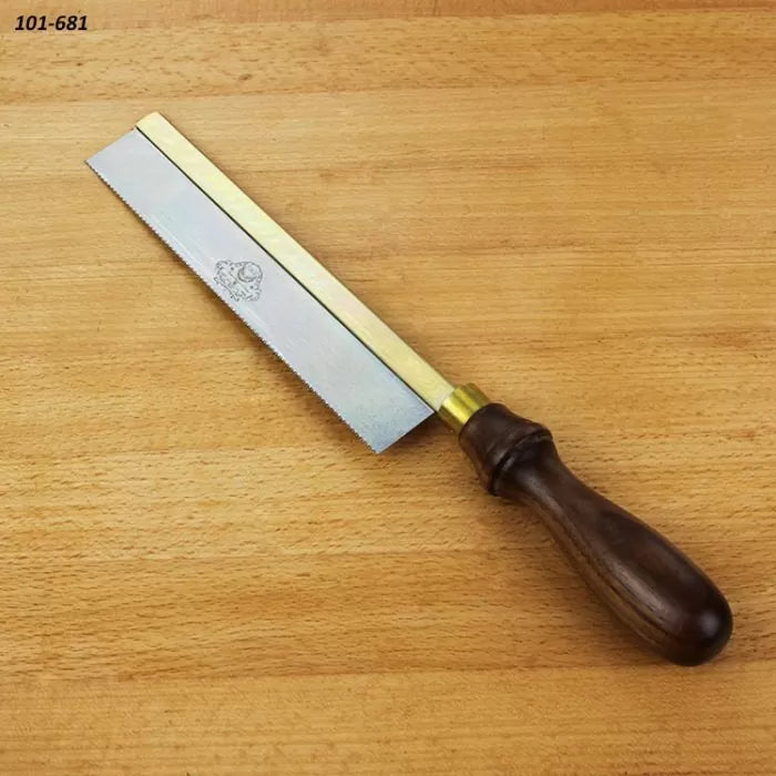 Dovetail saw with brass back and wooden handle on a wooden workbench, woodworking tool.