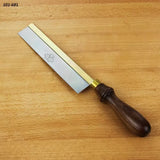Dovetail saw with brass back and wooden handle on a wooden workbench, woodworking tool.