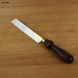 Small dovetail saw with brass back and wooden handle on a wood surface, woodworking tool