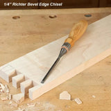 1/4 inch bevel edge chisel with wooden handle on a woodworking bench and dovetail joint