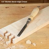 Half inch bevel edge chisel with wooden handle on a workbench and dovetailed wood board.