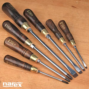 Set of wood-handled screwdrivers with brass ferrules on a wooden surface