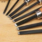 Set of woodworking chisels with square tips arranged on a wooden surface