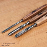 Three-piece straight gouge set with polished steel blades and wooden handles on a wood surface
