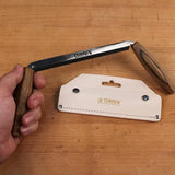 Narex woodworking tenon saw with wooden handle and leather sheath on workbench