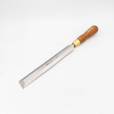 Woodworking chisel with beveled steel blade and wooden handle on white background