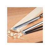 Woodworking chisels shaving wood strips on a workbench, precision hand tools for carpentry