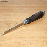 Bench chisel with beveled blade and wooden handle on a woodworking table