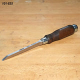 Woodworking chisel with dark wood handle on a workbench, ideal for precise carving