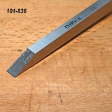 Bevel edge chisel with rectangular steel blade on a woodworking bench