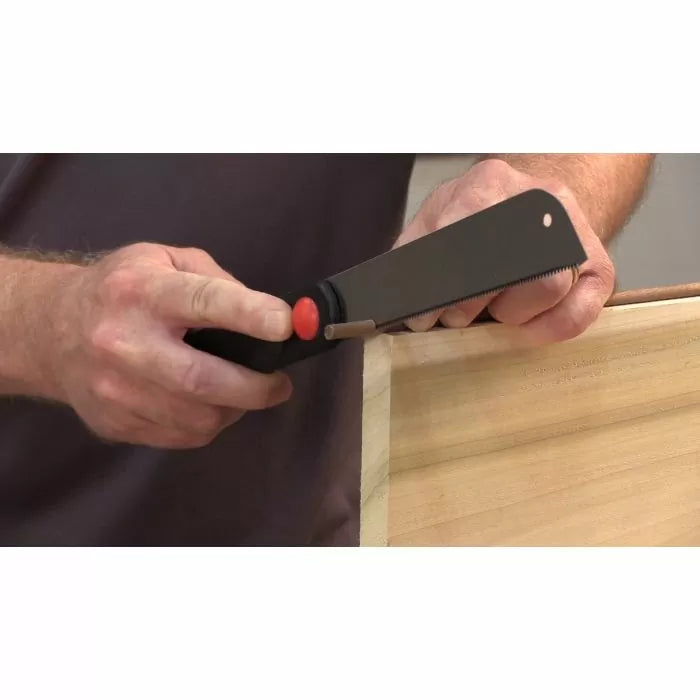 Woodworker using a flush cut saw to trim dowel on wooden project corner