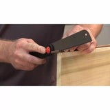 Woodworker using a flush cut saw to trim dowel on wooden project corner