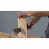 Person using a hand saw to cut plywood on a woodworking bench