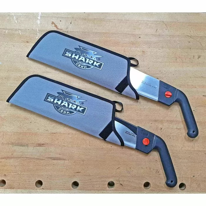 Two Japanese pull saws with protective covers on a woodworking bench