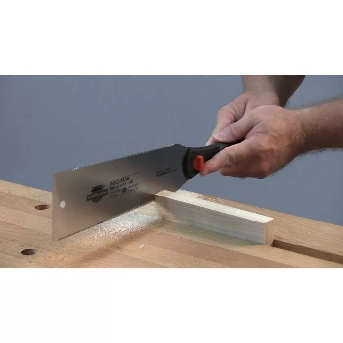 Hands using a pull saw to cut wood on a workbench, woodworking hand tool in action