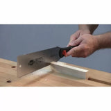 Hands using a pull saw to cut wood on a workbench, woodworking hand tool in action