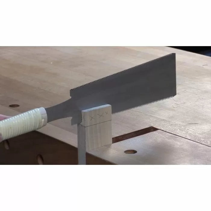 Japanese pull saw cutting dovetail joints on wood at a workbench