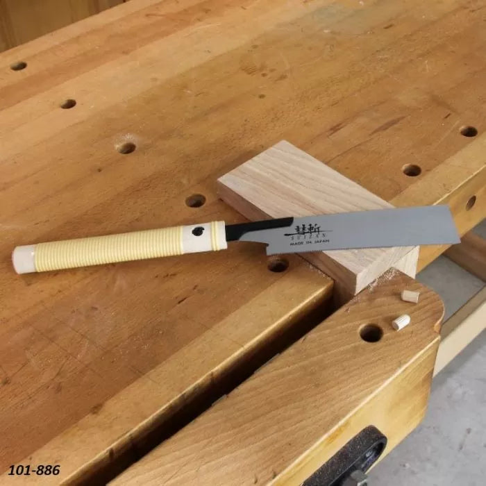 Japanese pull saw on woodworking bench cutting hardwood block, woodworking hand tool