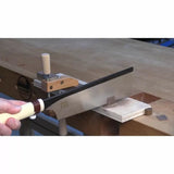 Woodworker using a Japanese pull saw and dovetail jig on a workbench for precise cuts