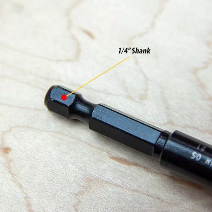 Close-up of 1/4 inch hex shank drill bit on wood surface, woodworking tool detail.