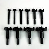 Set of ten black forstner drill bits for woodworking on white background.