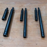 Three-piece set of black steel woodworking jig rods on a workbench
