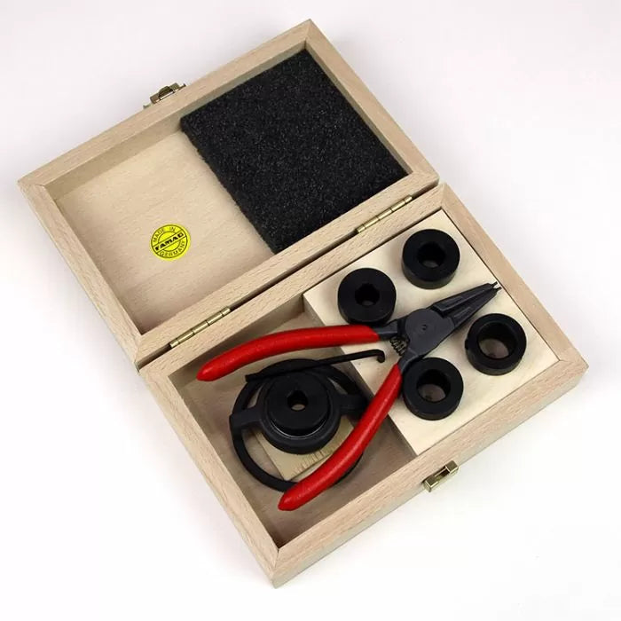 Router collet reducer set with red-handled pliers in a wooden box, woodworking tool kit