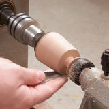 Woodworker using lathe tool to shape wood on a lathe, creating smooth woodturning.