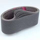 Abrasive sanding belt for woodworking, folded and textured, on a white background.