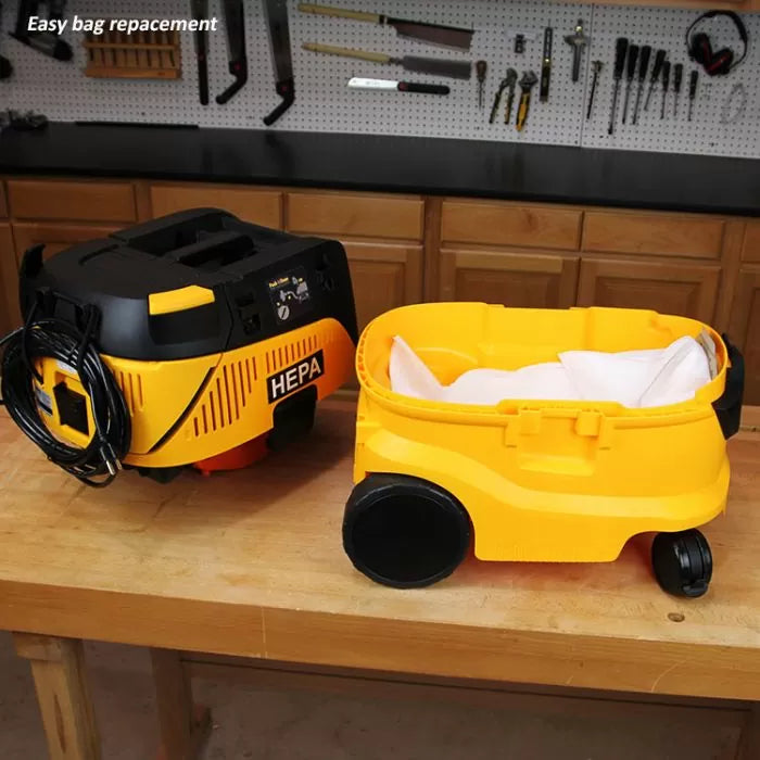 HEPA filter shop vacuum with easy bag replacement, shown open on a woodworking bench