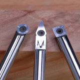 Set of three carbide woodturning tools with different cutter shapes on a wood surface